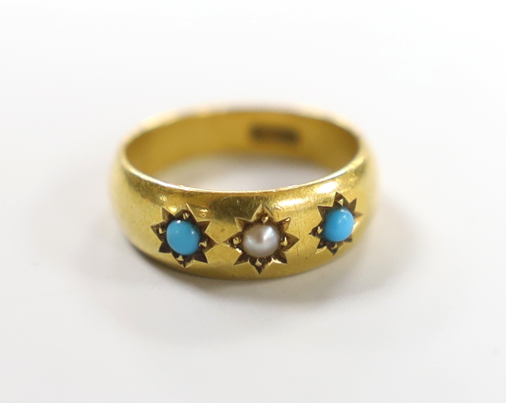 An early 20th century 18ct and gypsy set turquoise and seed pearl three stone child's ring, size A, gross weight 2.6 grams.